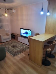 a living room with a table and a television at Beach View Apartment, Golem Durres in Durrës