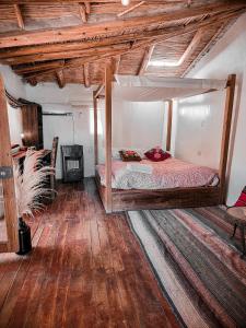 ein Schlafzimmer mit einem Bett in einem Zimmer mit Holzdecken in der Unterkunft Wolf Totem Mountain Top Dream Villa in Pisac