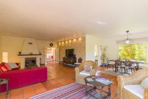 a living room with a red couch and a fireplace at Villa Goreti in Aroeira