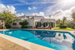 a swimming pool in front of a house at Villa Goreti in Aroeira