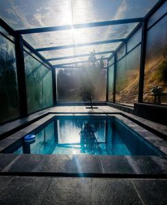 a swimming pool in a house with windows at Wolf Totem Mountain Top Dream Villa in Pisac