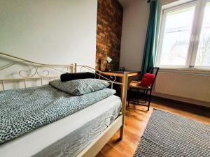 a bedroom with a bed and a desk and a window at Apartament z ogrodem w sercu Torunia in Toruń