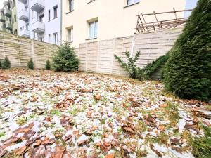 a pile of leaves on the ground in front of a building at Apartament z ogrodem w sercu Torunia in Toruń