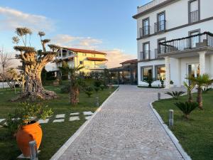 a house with a walkway in front of a building at Evergreen Laguna Vain-Lezhe in Lezhë