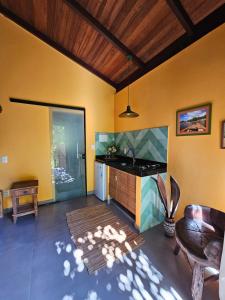 uma sala de estar com uma cozinha com uma bancada em HaraMatha em Barra Grande