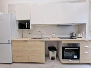 a kitchen with white cabinets and a sink and a refrigerator at Loft Seco super equipado cerca de metro Pacífico in Madrid