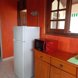 uma cozinha com um frigorífico branco e um micro-ondas em Villa bella em Sainte-Anne