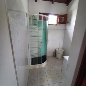 uma casa de banho com um chuveiro e uma porta de vidro em Villa bella em Sainte-Anne