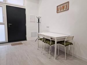 a white table and chairs in a room with a black door at Loft Seco super equipado cerca de metro Pacífico in Madrid