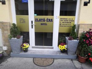 uma porta da frente de um edifício com vasos de plantas em ZLATÁ-ÉRA em Ostrava