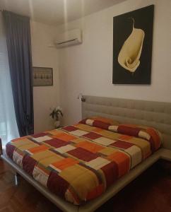 a bedroom with a bed with a colorful blanket at La Casa di Cristina in Livorno