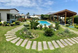 a garden with a swimming pool and a house at Kuyayky Lodge in Lima