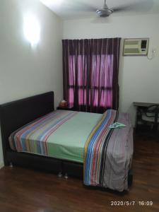 a small bedroom with a bed and a window at Seri Maya -Lrt setiawangsa - Master Room with shared unit in Kuala Lumpur