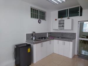 a kitchen with white cabinets and a black refrigerator at Casa para 15 personas - Playas, villamil in Playas