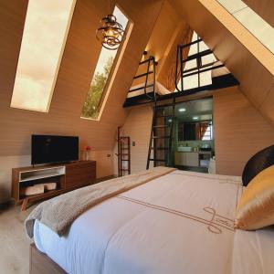 a bedroom with a bed with a tv and a staircase at Cádiz Hotel Boutique in Villa de Leyva +17 photos