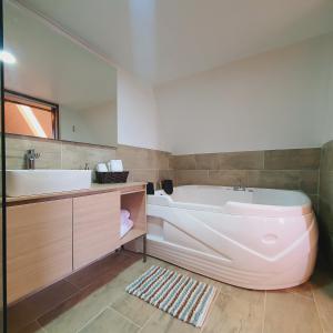 baño con bañera grande y lavamanos en Cádiz Hotel Boutique, en Villa de Leyva