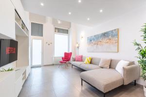 een woonkamer met een bank en een rode stoel bij Loft Salgari in Turijn
