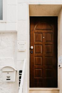 una porta marrone su un edificio con un cestino di Le Contrade Vico Alba a Monopoli