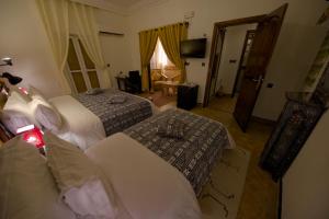 a hotel room with two beds and a television at Tin Joseph in Ouarzazate