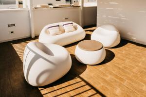 a living room with three white chairs and a couch at Le Contrade Vico Alba in Monopoli
