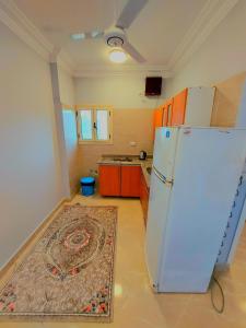 a kitchen with a white refrigerator and a rug at Luxor apartment in Luxor