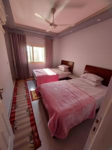 a hotel room with two beds and a window at Luxor apartment in Luxor