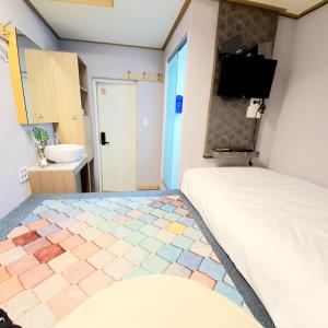 a bedroom with a bed and a tiled floor at Bao Guesthouse in Seoul