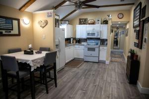 a kitchen with white cabinets and a table with chairs at Stockyards Cowtown Outpost-Less than 4 minutes to StockYards-Sleeps 8 in Fort Worth