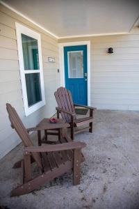 Deux chaises assises à l'extérieur d'une maison avec une porte bleue dans l'établissement Stockyards Cowtown Outpost-Less than 4 minutes to StockYards-Sleeps 8, à Fort Worth