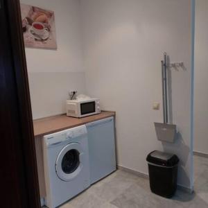 a washing machine with a microwave on top of it at IJD apartments 126 PARKING GRATIS Y PISCINA in Bormujos