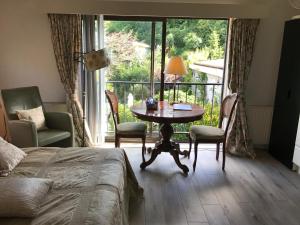 a bedroom with a table and chairs and a balcony at Villa 't Haasduin in Wijk aan Zee