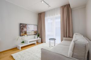 - un salon blanc avec un canapé et une fenêtre dans l'établissement Tartu City Center Apartments, à Tartu