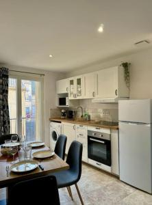cocina con mesa y nevera blanca en Appartement lumineux avec terrasses, en Le Luc