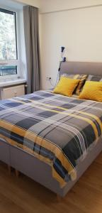 Una cama con una manta azul y amarilla. en Luksusowy Apartament Nad Zalewem, en Serock