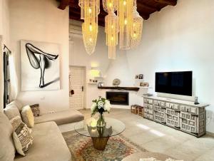 a living room with a television and a vase of flowers at Ipunga Ibiza - Adults only in Cala Llonga