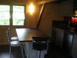 a kitchen with a counter and chairs in a cabin at Propriete de 2 chambres avec wifi a Taninges a 7 km des pistes in Taninges