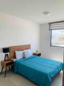 um quarto com uma cama azul e uma janela em Amplia casa cerca de zona industrial em San Luis Potosí