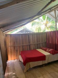 Una habitación con cama en una tienda en Miguel Surf Camp en Quepos