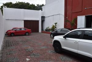 dos autos estacionados en un estacionamiento al lado de un edificio en Hotel Boutique Boca - Veracruz, en Boca del Río