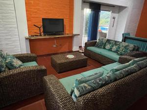 a living room with two couches and a tv at Finca Aguadalupe, Lago Calima in Calima