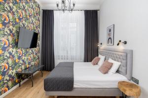 een slaapkamer met een bed en een tv aan de muur bij Wawel Apartments - Old Town in Krakau