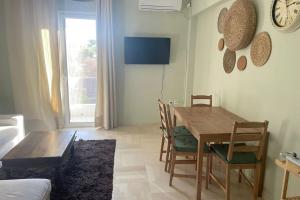 - un salon avec une table et des chaises en bois dans l'établissement Charming Apartment in Varkiza, à Varkiza