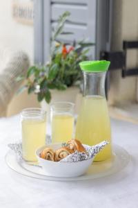 a plate with a bowl of donuts and a bottle of orange juice at Charming Apartment in Varkiza in Varkiza