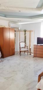 ein Wohnzimmer mit einem Stuhl und einem Schrank in der Unterkunft Algo2 in Salamís
