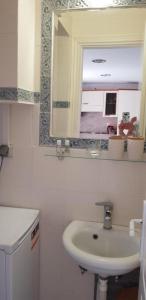 ein weißes Badezimmer mit einem Waschbecken und einem Spiegel in der Unterkunft Algo2 in Salamís