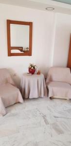 ein weißes Zimmer mit einem Tisch und einem Spiegel in der Unterkunft Algo2 in Salamís