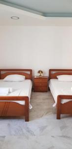 2 Betten in einem Zimmer mit 2 Tischen und 2 Betten sidx sidx sidx sidx in der Unterkunft Algo2 in Salamís