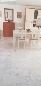 un comedor con mesas blancas y sillas blancas en Algo2 en Salamís