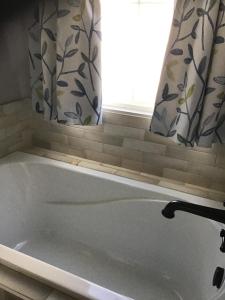 a bath tub in a bathroom with a window at Donna’s Sunset Meadow in Loudon