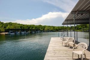 a row of chairs sitting on a dock next to the water at Indian Point Villa#5 at Tribesman Resort on Table Rock Lake near Silver Dollar City, Branson in Branson